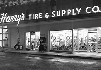 Harry’s Tire & Supply Co. sign lit up at night.